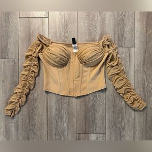Cropped corset top with mesh sleeves.